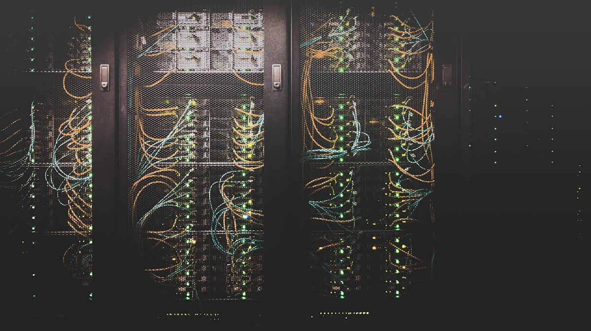 Server racks in a data center with orange and green fiber cabling